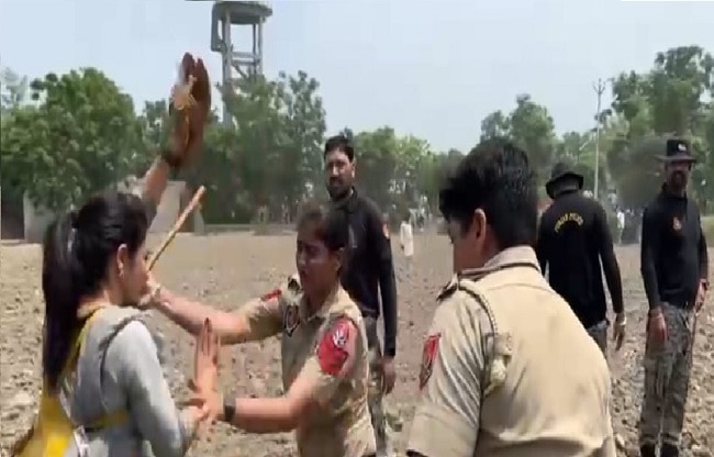 महिला प्रदर्शनकारी को पकड़ती हुई पुलिस.