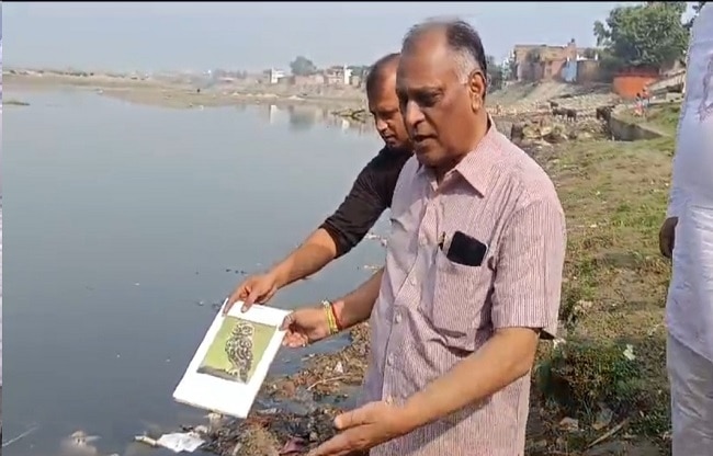 नदी में उल्लू की तस्वीर बहाते हुए प्रोफेसर.