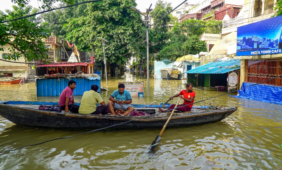 People take a boat ride at an area inundated with the Ganga river water, in Varanasi (PTI Photo)