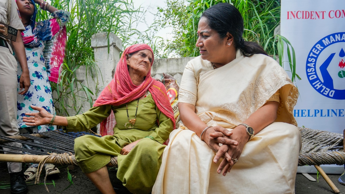 दिल्ली: गीता कॉलोनी के पास बाढ़ क्षेत्र के दौरे के दौरान महिला से बातचीत करती सीएम रेखा गुप्ता. (photo: PTI)