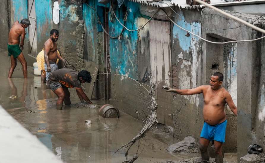People clean their houses filled with mud after the water level of the Yamuna river recedes in New Delhi, Sunday, Sept. 7, 2025. (PTI Photo/Shahbaz Khan)