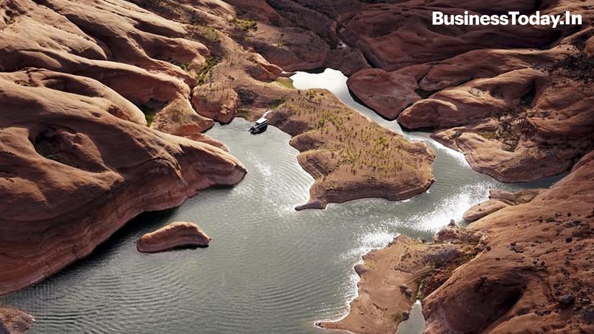 A houseboat camps on the shore in shallow water in a canyon at Lake Powell near Page, Arizona. The lake, on the Colorado River provides water for Nevada, Arizona and California.