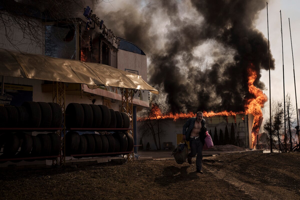 A man recovers items from a shop that caught fire from a Russian attack in Kharkiv, Ukraine.