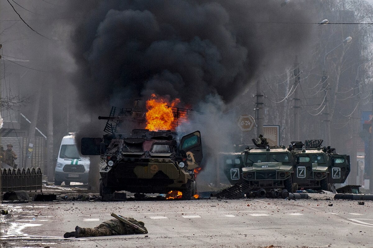 A Russian armored personnel carrier burns amid damaged and abandoned light utility vehicles after fighting in Kharkiv, Ukraine.