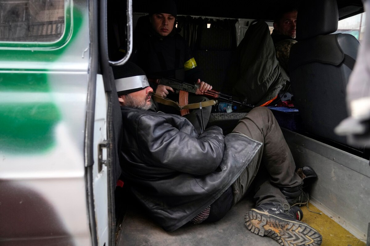 Ukrainian troops escort a suspected Russian agent in Kyiv, Ukraine.