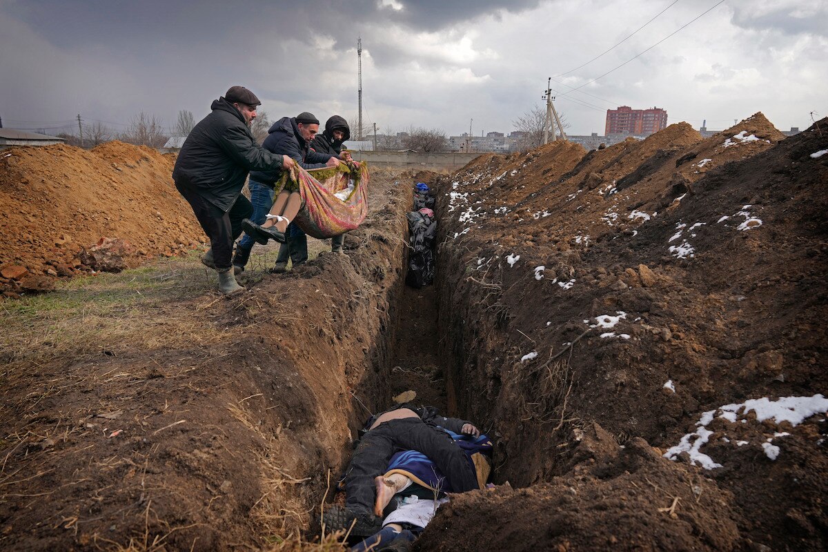 Bodies are placed into a mass grave on the outskirts of Mariupol, Ukraine.