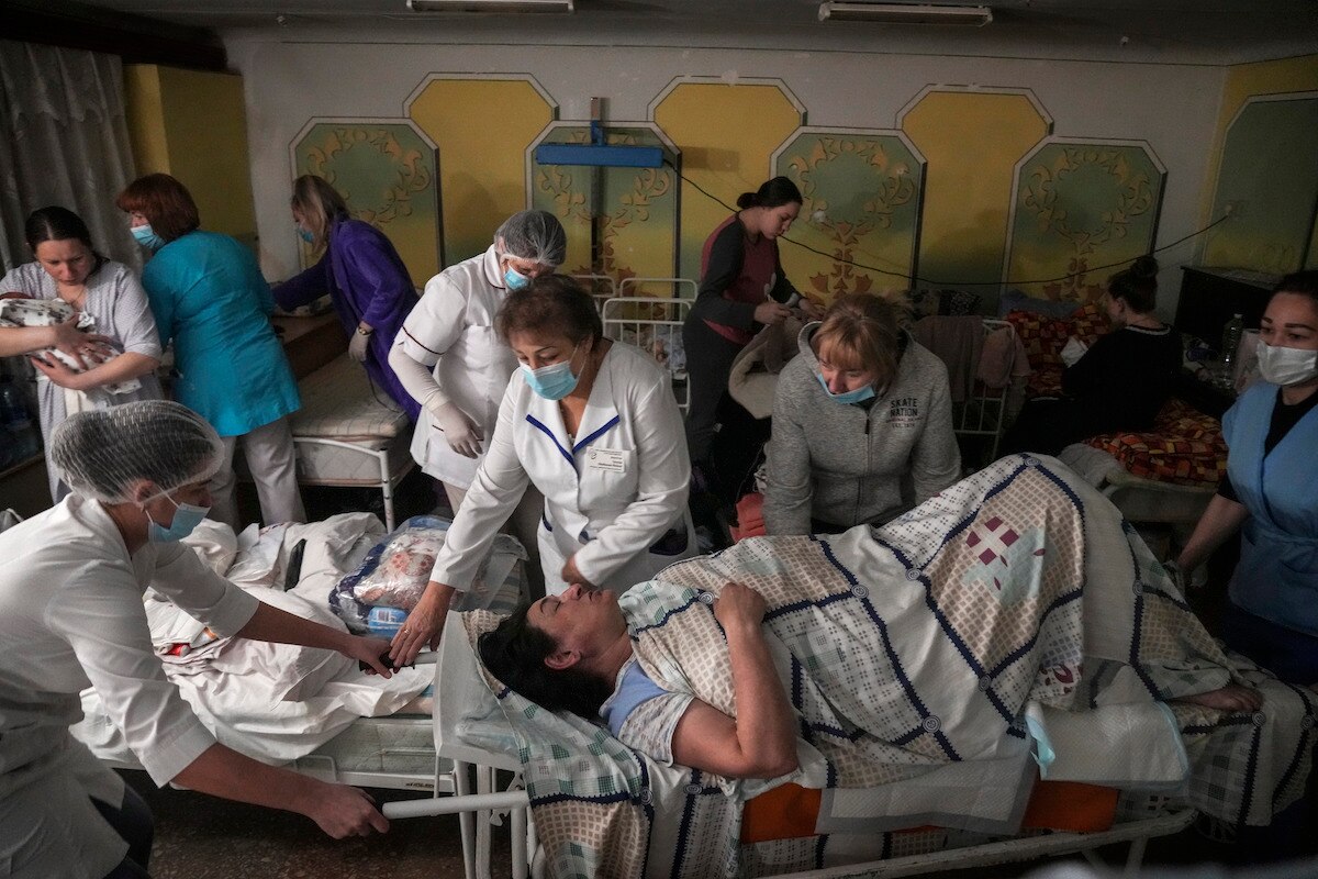 Medical workers move a patient in the basement of a maternity hospital that has been converted into a medical ward and bomb shelter in Mariupol, Ukraine.
