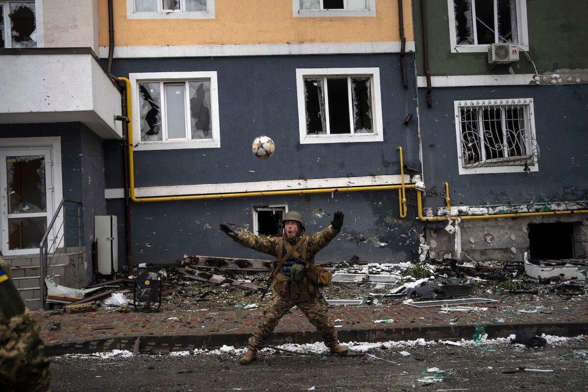 A Ukranian soldier plays a pick-up game in Irpin on the outskirts of Kyiv, Ukraine.
