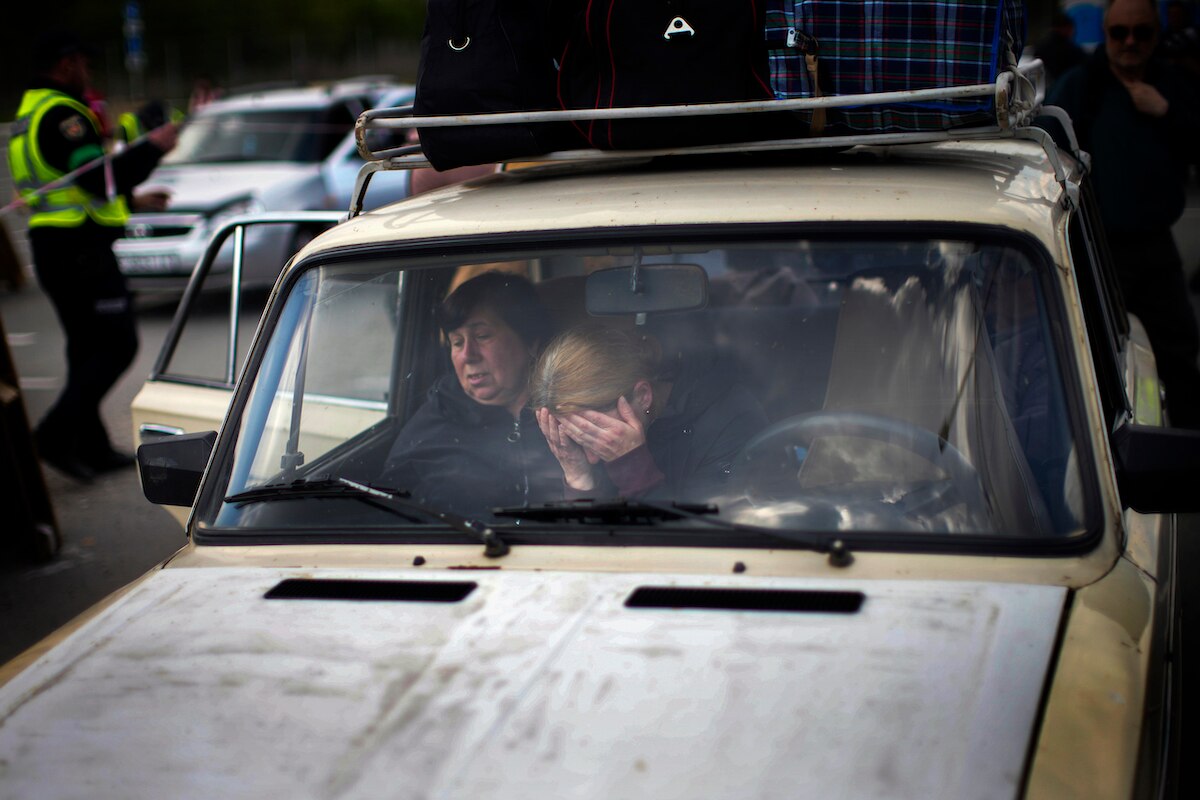 People wait in a car to be processed at a reception center for displaced people in Zaporizhzhia, Ukraine.