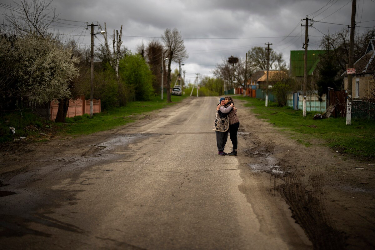 Tetyana Boikiv, right, hugsher neighbor Svitlana Pryimachenko aftera funeral service for Boikiv’s husband, Mykola Moroz, in the Ozera village near Bucha, Ukraine.