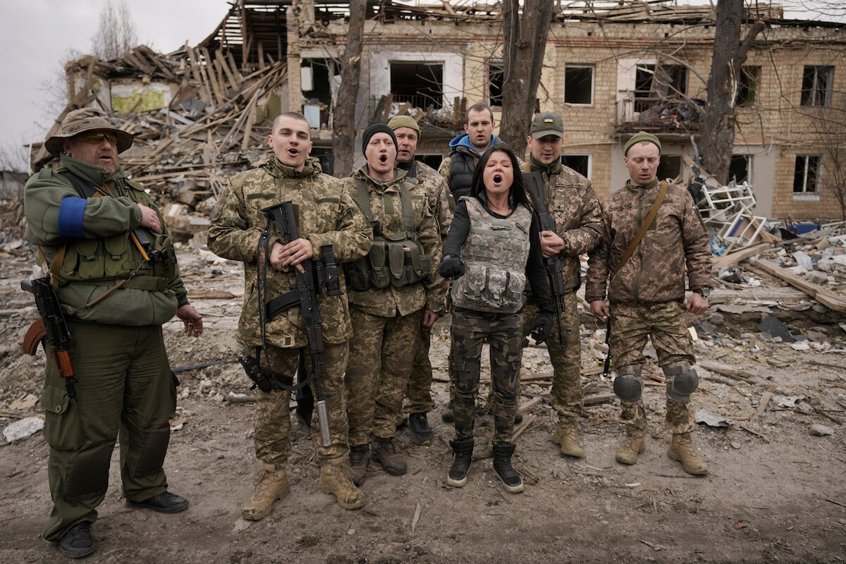 Ukrainian servicemen sing a patriotic song amid buildings destroyed during fighting between Ukrainian and Russian forces in Borodyanka, Ukraine.