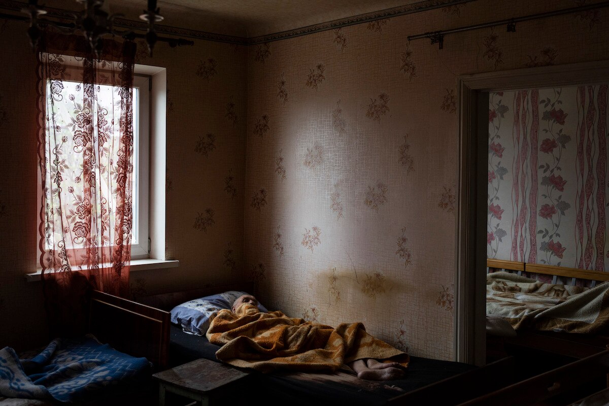 An elderly man lies at a hospice center in Chasiv Yar in the Donetsk district of Ukraine.