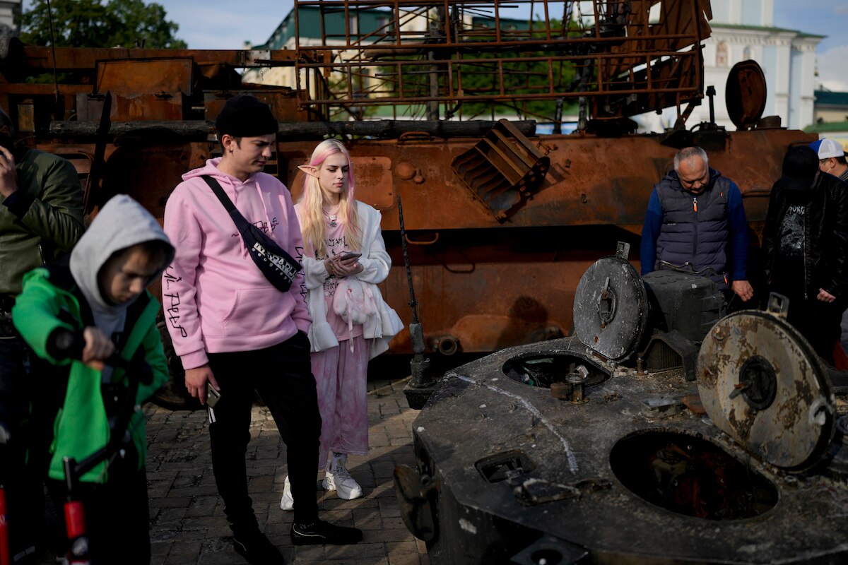 People look at a destroyed Russian tank placed at Mykhailivs'ka Square in downtown Kyiv, Ukraine.