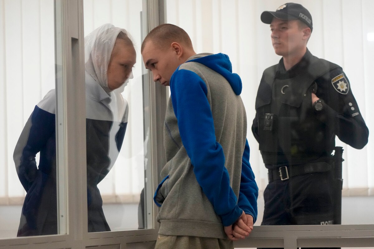Russian Sgt. Vadim Shishimarin listens to his translator during his court hearing in Kyiv, Ukraine.