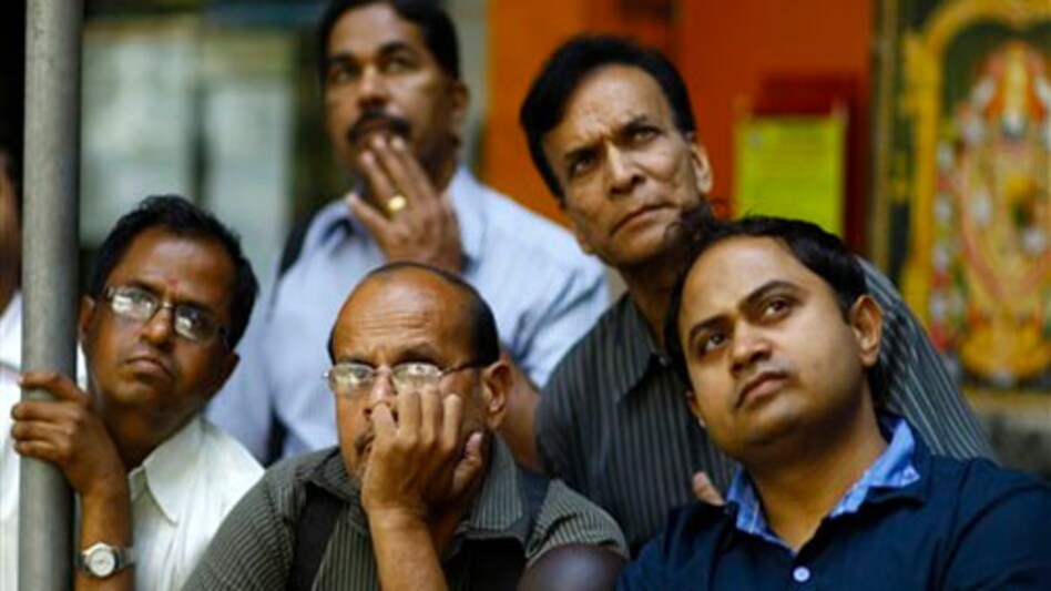 Investors keep an eye on stock movement outside the Bombay Stock Exchange. PHOTO: AP Investors keep an eye on stock movement outside the Bombay Stock Exchange. PHOTO: AP