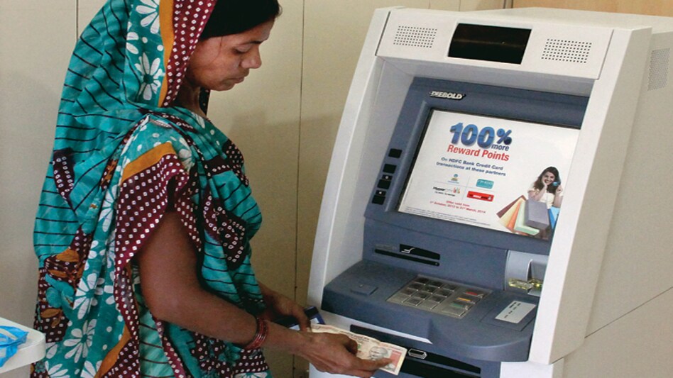 Towards inclusion: A customer draws cash at the branch in Bavla village, some 35 km from Ahmedabad. PHOTO: SHAILESH RAVAL Towards inclusion: A customer draws cash at the branch in Bavla village, some 35 km from Ahmedabad. PHOTO: SHAILESH RAVAL