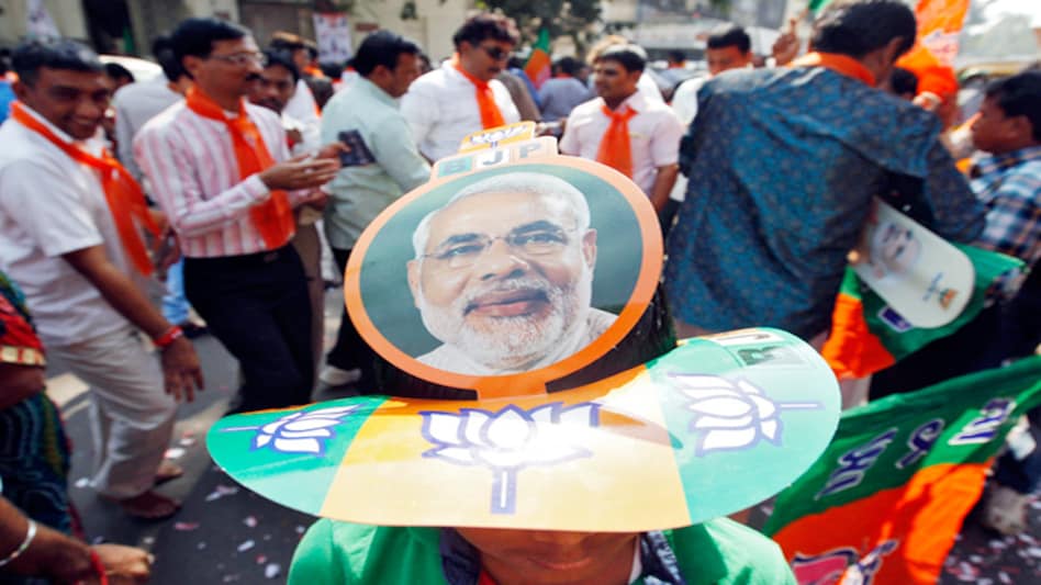 Supporters carrying a picture of Gujarat's chief minister Narendra Modi, the prime ministerial candidate for Bharatiya Janata Party (BJP), attend the celebrations outside the party's headquarters in Gujarat on December 8, after the results in Assembly ele Supporters carrying a picture of Gujarat's chief minister Narendra Modi, the prime ministerial candidate for Bharatiya Janata Party (BJP), attend the celebrations outside the party's headquarters in Gujarat on December 8, after the results in Assembly ele