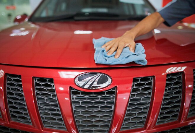 A showroom attendant cleans a Mahindra XUV500 car inside the company's showroom in Mumbai. Photo: Reuters