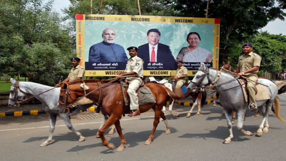 Police personnel patrol on their horses past a boarding with images of (L-R) Prime Minister Narendra Modi, China's President Xi Jinping and Anandiben Patel, Chief Minister of Gujarat, ahead of Xi's arrival in Ahmedabad (Photo: Reuters) Police personnel patrol on their horses past a boarding with images of (L-R) Prime Minister Narendra Modi, China's President Xi Jinping and Anandiben Patel, Chief Minister of Gujarat, ahead of Xi's arrival in Ahmedabad (Photo: Reuters)