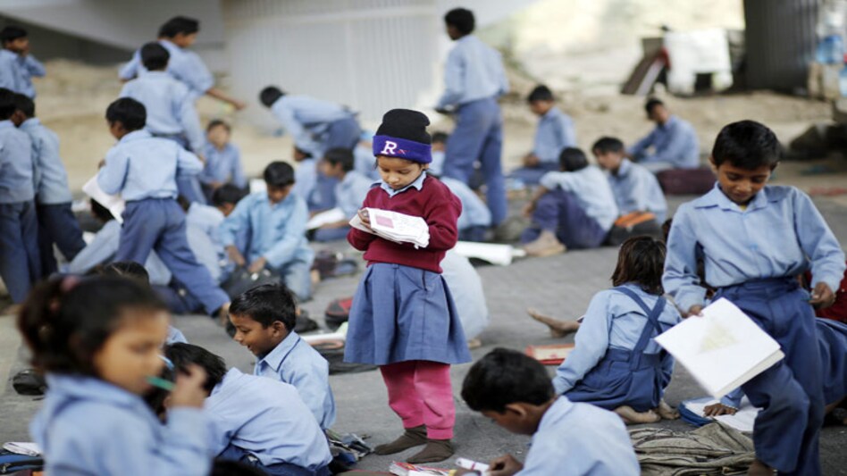 A schoolgirl reads from a textbook at an open-air school in New Delhi. (Photo: Reuters) A schoolgirl reads from a textbook at an open-air school in New Delhi. (Photo: Reuters)