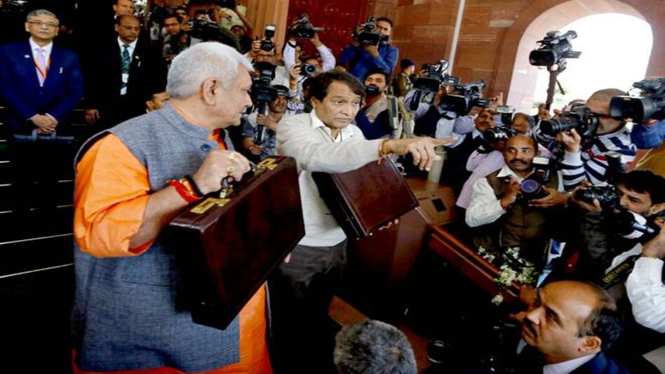 Railway Minister Suresh Prabhu (C) gestures upon his arrival at Parliament to present the Railway Budget in New Delhi. Railway Minister Suresh Prabhu (C) gestures upon his arrival at Parliament to present the Railway Budget in New Delhi.
