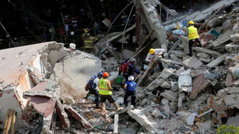 Rescue personnel remove rubble at a collapsed building while searching for people after an earthquake hit Mexico City, Mexico Rescue personnel remove rubble at a collapsed building while searching for people after an earthquake hit Mexico City, Mexico