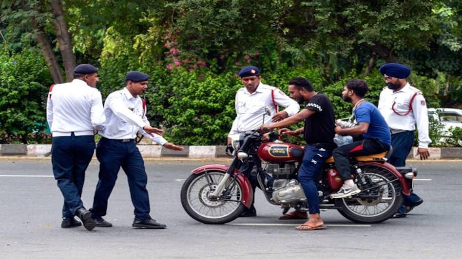 Traffic policemen stop a motorcyclist riding without helmet as the newly amended Motor Vehicles Act comes into force from Sept 1. Traffic policemen stop a motorcyclist riding without helmet as the newly amended Motor Vehicles Act comes into force from Sept 1.