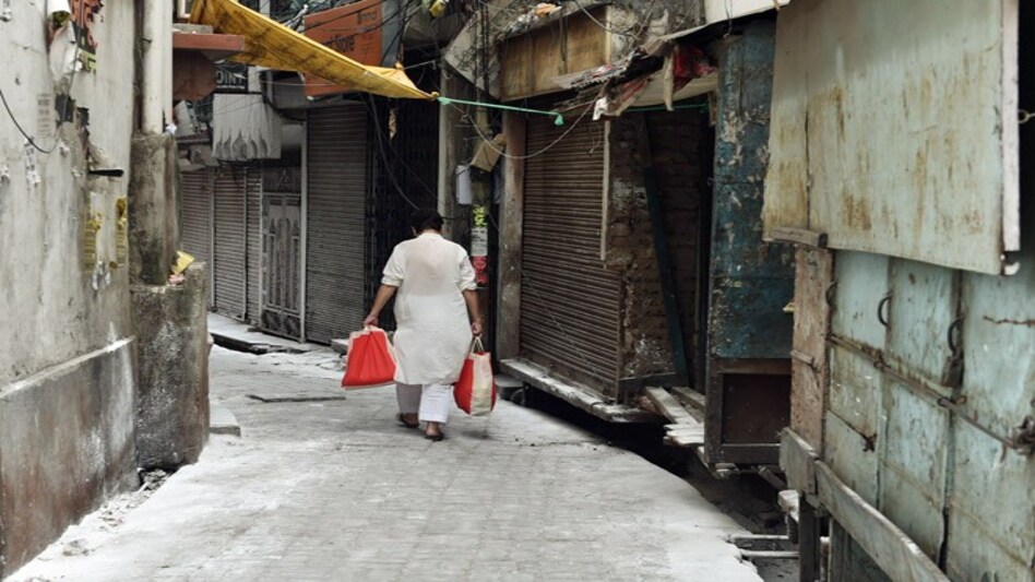 A man returns home after collecting essential items from a delivery person in a sealed area in Aminabad, Lucknow (Photo credit: PTI) A man returns home after collecting essential items from a delivery person in a sealed area in Aminabad, Lucknow (Photo credit: PTI)
