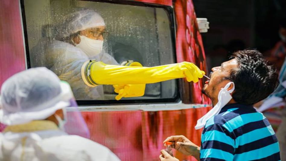 A health official collects sample for a swab test from a mobile testing van in Ahmedabad A health official collects sample for a swab test from a mobile testing van in Ahmedabad