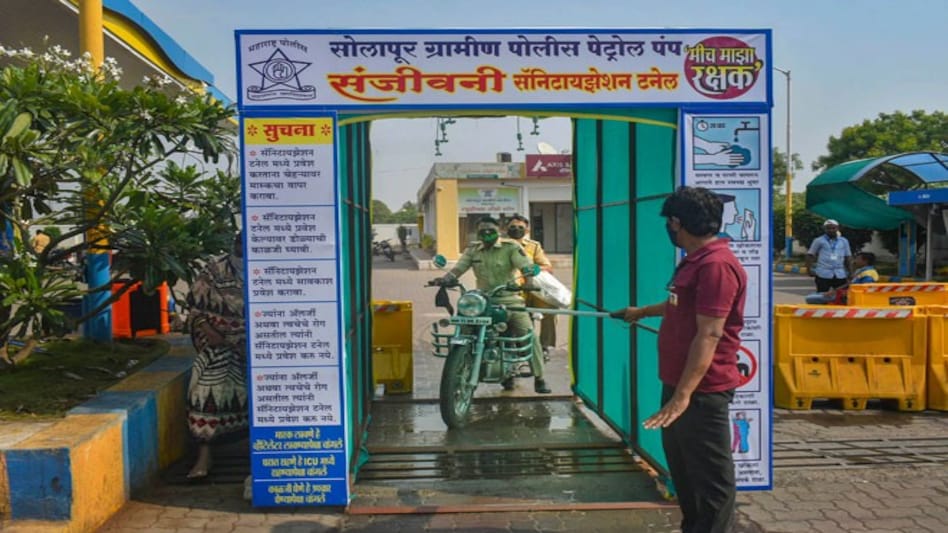 Police personnel pass through a sanitisation tunnel (Photo credit: PTI) Police personnel pass through a sanitisation tunnel (Photo credit: PTI)