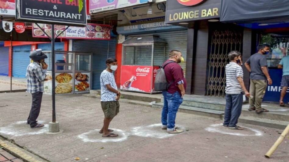 People line outisde a liquor store in Guwahati (Photo credit: PTI) People line outisde a liquor store in Guwahati (Photo credit: PTI)