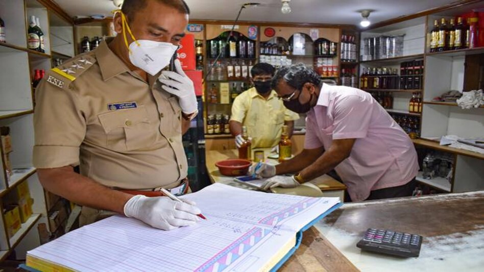 An excise official checks the stock at a wine shop in Bengaluru An excise official checks the stock at a wine shop in Bengaluru