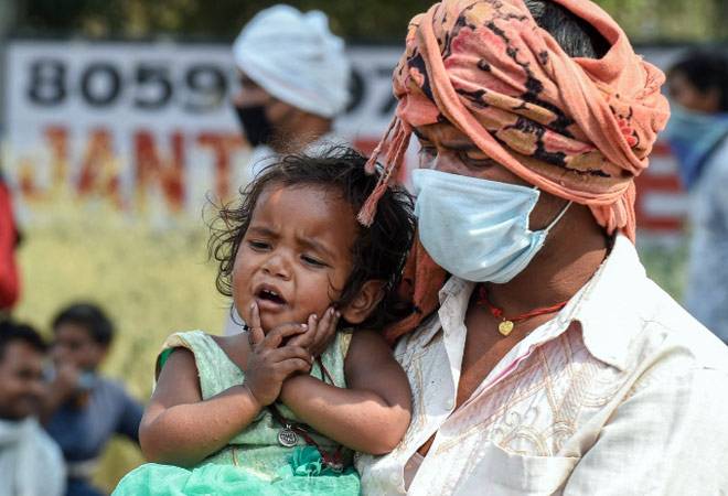 Migrants wait for a means of transport to travel to their native places during the fourth phase of the ongoing COVID-19 nationwide lockdown, at Kundali Industrial Area in Sonipat. (Photo: PTI) Migrants wait for a means of transport to travel to their native places during the fourth phase of the ongoing COVID-19 nationwide lockdown, at Kundali Industrial Area in Sonipat. (Photo: PTI)