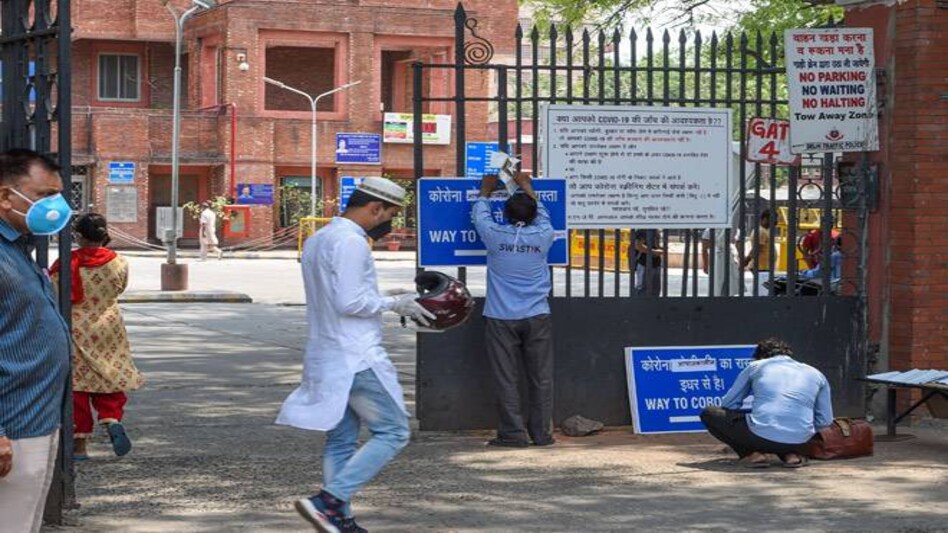 A worker hangs a notice on the main gate of Delhi's LNJP Hospital during the ongoing COVID-19 lockdown A worker hangs a notice on the main gate of Delhi's LNJP Hospital during the ongoing COVID-19 lockdown