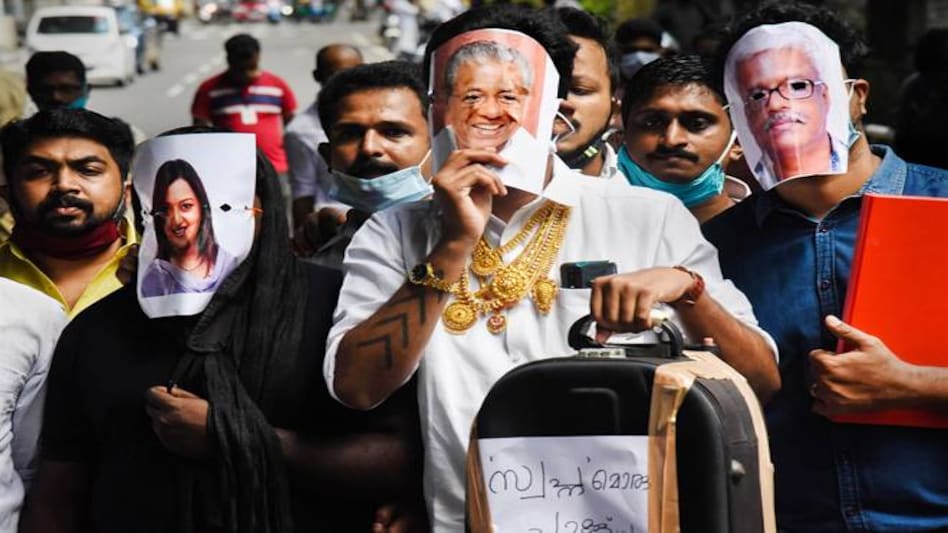 Youth Congress activists hold pictures of Kerala Chief Minister Pinarayi Vijayan (C), former UAE consulate officer Swapna Suresh (L), and State IT Secretary M Sivasankar (R) during a protest over the Kerala gold smuggling case. (Photo: PTI) Youth Congress activists hold pictures of Kerala Chief Minister Pinarayi Vijayan (C), former UAE consulate officer Swapna Suresh (L), and State IT Secretary M Sivasankar (R) during a protest over the Kerala gold smuggling case. (Photo: PTI)
