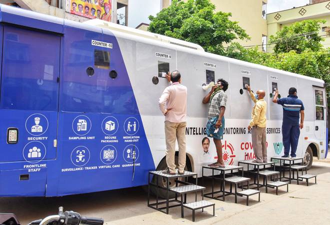People stand near a COVID-19 mobile testing facility in Hyderabad People stand near a COVID-19 mobile testing facility in Hyderabad