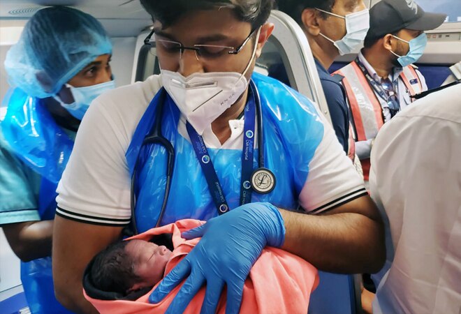 An airline medical official holds the baby born on board Indigo flight on Wednesday An airline medical official holds the baby born on board Indigo flight on Wednesday