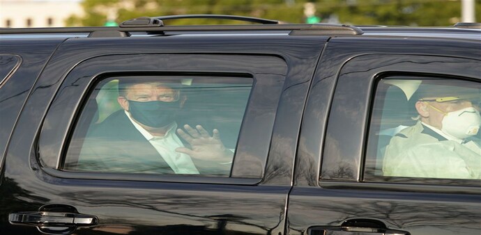 Wearing a mask, US President Donald Trump waved at his supporters from his car outside Walter Reed National Military Medical Centre Wearing a mask, US President Donald Trump waved at his supporters from his car outside Walter Reed National Military Medical Centre
