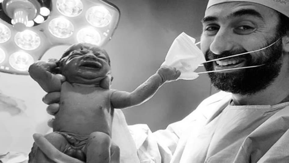 The picture of a baby girl trying to tear off her doctor's mask is seen as a symbol of the possible end of coronavirus The picture of a baby girl trying to tear off her doctor's mask is seen as a symbol of the possible end of coronavirus