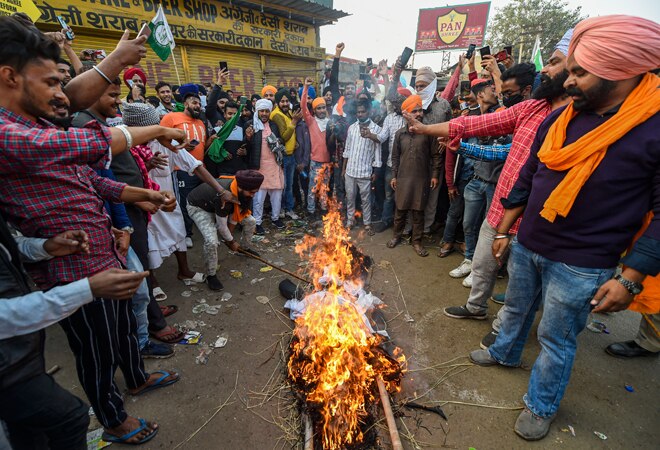 Farmers burn an effigy during their ongoing Delhi Chalo agitation against the new farm laws, at Singhu border Farmers burn an effigy during their ongoing Delhi Chalo agitation against the new farm laws, at Singhu border