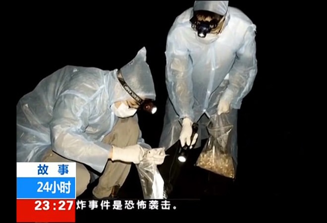 Evidence: Researchers in thin coveralls and rubber gloves handle bats while gathering samples in a clip filmed by a Chinese television crew Evidence: Researchers in thin coveralls and rubber gloves handle bats while gathering samples in a clip filmed by a Chinese television crew