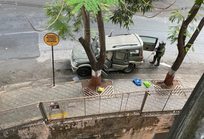 A member of the bomb disposal squad examines the abandoned car outside Mukesh Ambani's residence A member of the bomb disposal squad examines the abandoned car outside Mukesh Ambani's residence