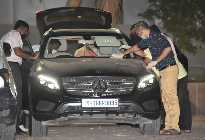 NIA officers investigate Sachin Vaze's Mercedes car following his arrest, in connection with a probe into the recovery of explosives from a car parked near industrialist Mukesh Ambani's house, in Mumbai. NIA officers investigate Sachin Vaze's Mercedes car following his arrest, in connection with a probe into the recovery of explosives from a car parked near industrialist Mukesh Ambani's house, in Mumbai.