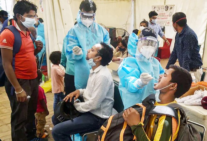 Healthcare workers taking samples for Covid-19 testing at Delhi's Anand Vihar Bus Terminal on Wednesday (Photo Credits: PTI) Healthcare workers taking samples for Covid-19 testing at Delhi's Anand Vihar Bus Terminal on Wednesday (Photo Credits: PTI)