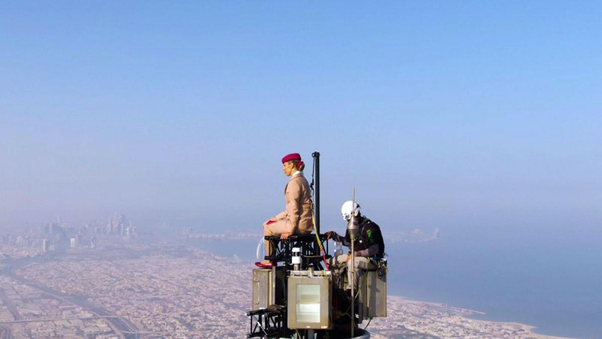 The new Emirates advertisement features a cabin crew member in full uniform standing tall on the tip of the Burj Khalifa by Emaar at 828 metres above the ground The new Emirates advertisement features a cabin crew member in full uniform standing tall on the tip of the Burj Khalifa by Emaar at 828 metres above the ground
