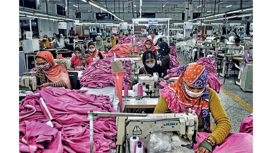 Workers at a clothing factory in Gurugram Workers at a clothing factory in Gurugram