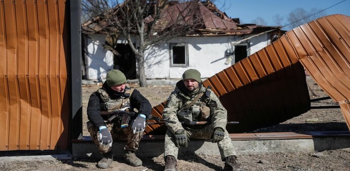Ukrainian service members are seen near a destroyed building in a village on the front line in the east Kyiv region. (Photo: Reuters) Ukrainian service members are seen near a destroyed building in a village on the front line in the east Kyiv region. (Photo: Reuters)