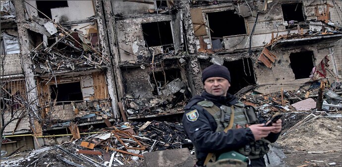 WAR ZONE: A Ukrainian police officer stands in front of a damaged residential block hit by a missile on February 25 in Kyiv WAR ZONE: A Ukrainian police officer stands in front of a damaged residential block hit by a missile on February 25 in Kyiv