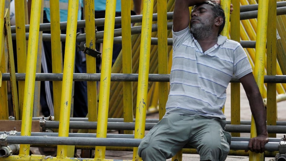 A man sleeps on a metal barrier on the 4th consecutive day of protests against Sri Lankan President Gotabaya Rajapaksa in front of the Presidential Secretariat, amid the country's economic crisis. (Photo: Reuters) A man sleeps on a metal barrier on the 4th consecutive day of protests against Sri Lankan President Gotabaya Rajapaksa in front of the Presidential Secretariat, amid the country's economic crisis. (Photo: Reuters)