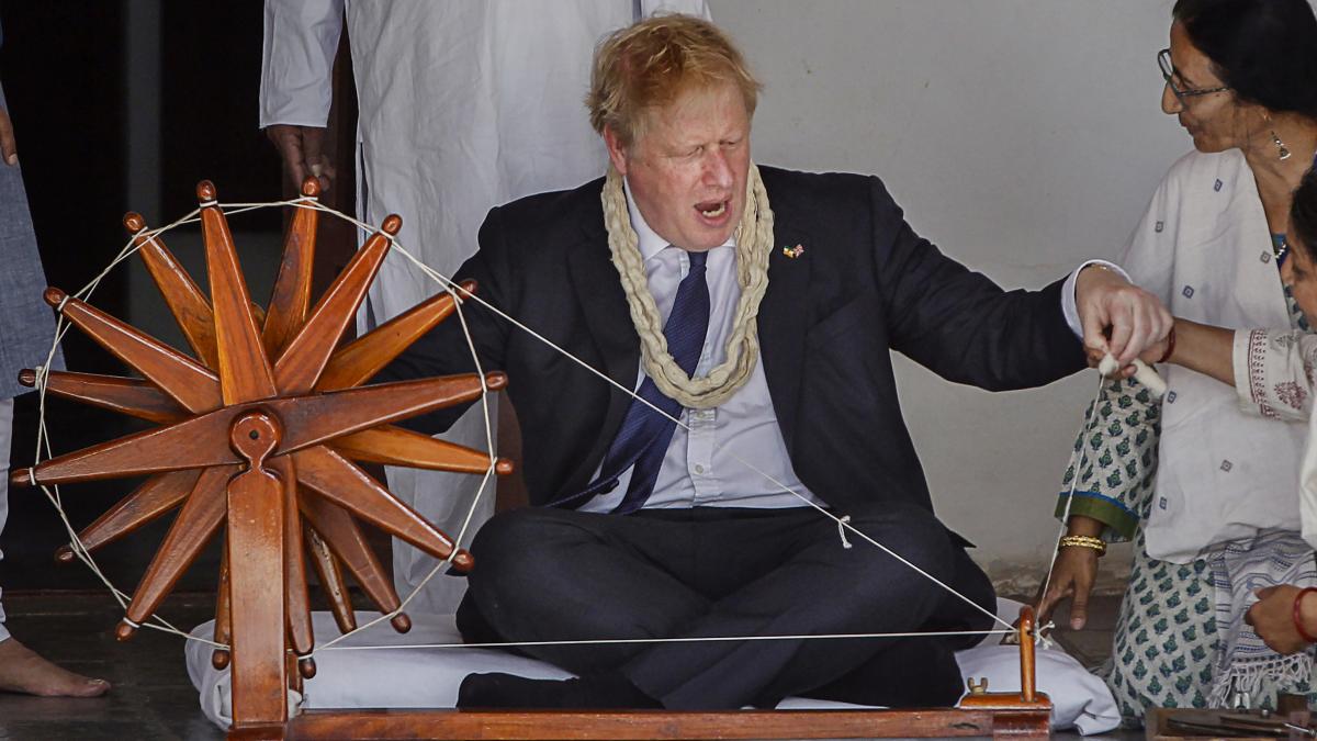 British Prime Minister Boris Johnson tries his hands on a spinning wheel during a visit to the Sabarmati Gandhi Ashram, in Ahmedabad. (PTI Photo) British Prime Minister Boris Johnson tries his hands on a spinning wheel during a visit to the Sabarmati Gandhi Ashram, in Ahmedabad. (PTI Photo)